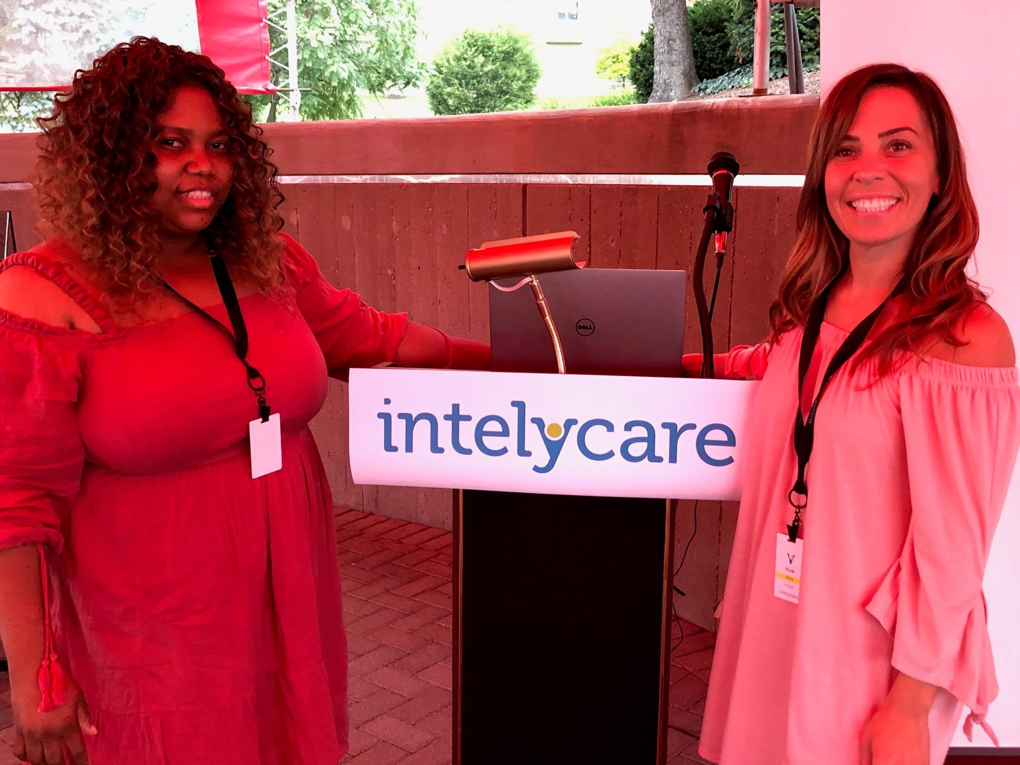 IntelyCare nurses smiling while standing at a podium during the welcome event in Cincinnati