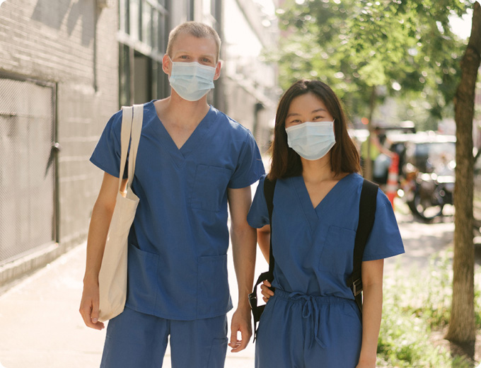 Two IntelyPro per diem nurses wearing masks on the street after attending covid-19 nurse training