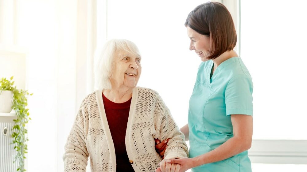 Nursing professional helping a resident amidst nursing home staffing shortages
