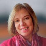 Woman with short hair and pink top.