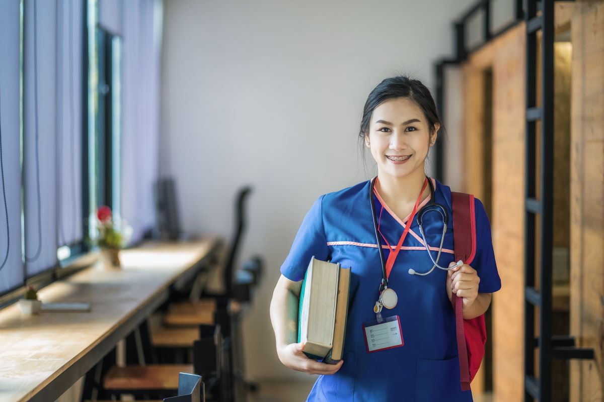 Travel nurse carrying bag and walking out of hotel lobby