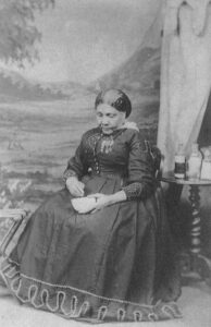 Mary Seacole seated and holding a mortar and pestle.