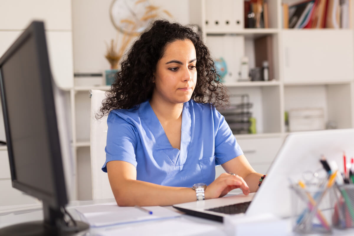 Nurse with curly dark hair working on her RN resume.