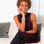 Image of content creator sitting on a couch and smiling at camera