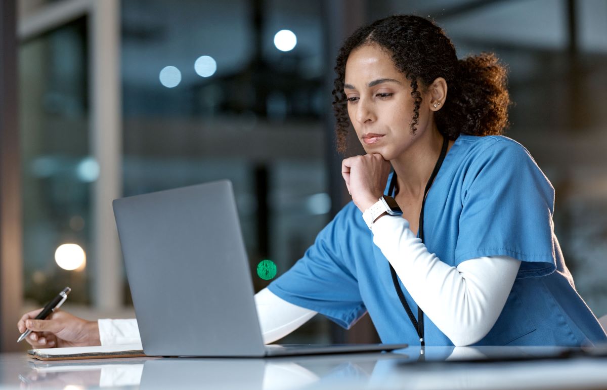 A nurse at her computer, figuring out how to create a newsletter for her facility.