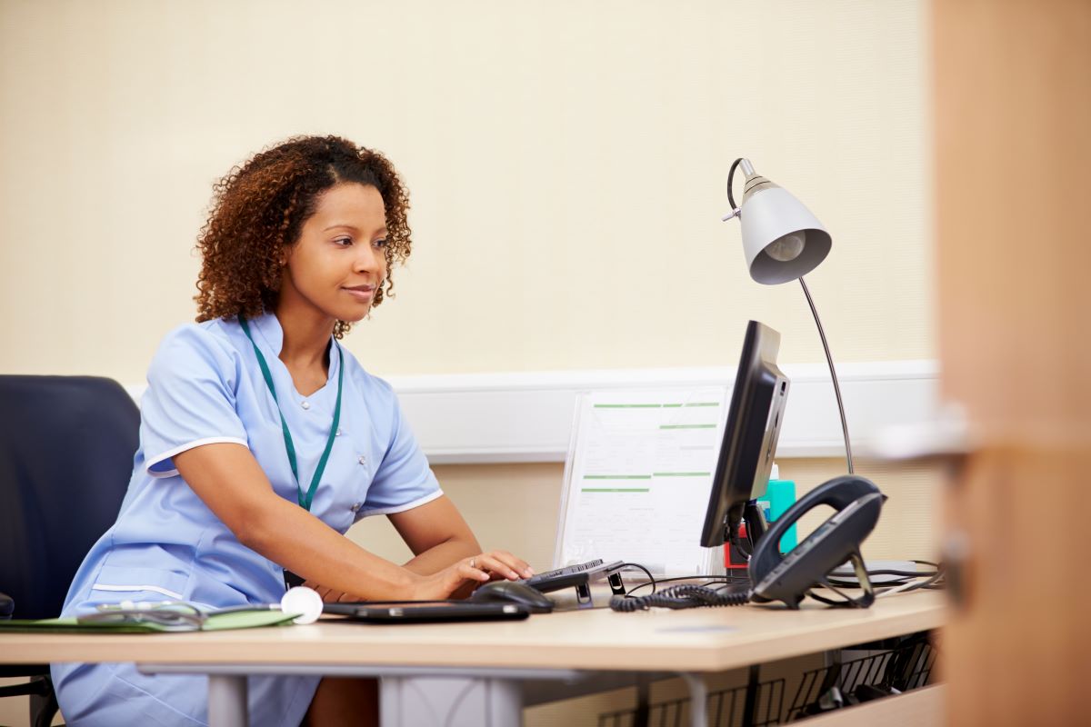 Nurse scheduler filling shifts on a computer in an office