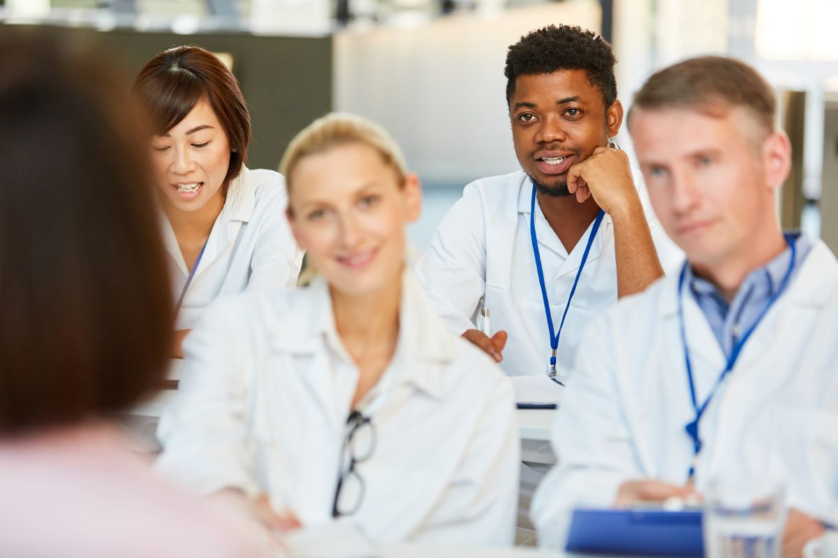 Colleagues listen to an instructor during a nursing professional development session.