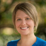 Woman with short blonde hair and blue shirt.