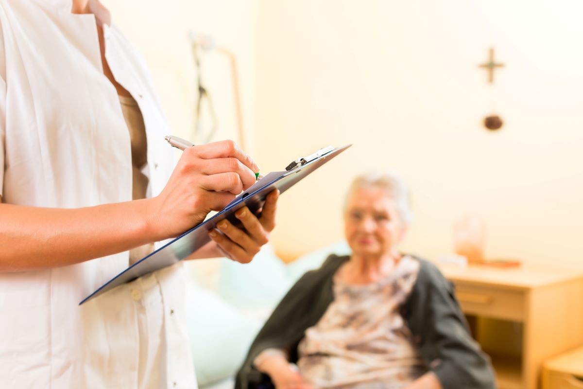 A CMS inspector taking notes during a visit to a nursing home.