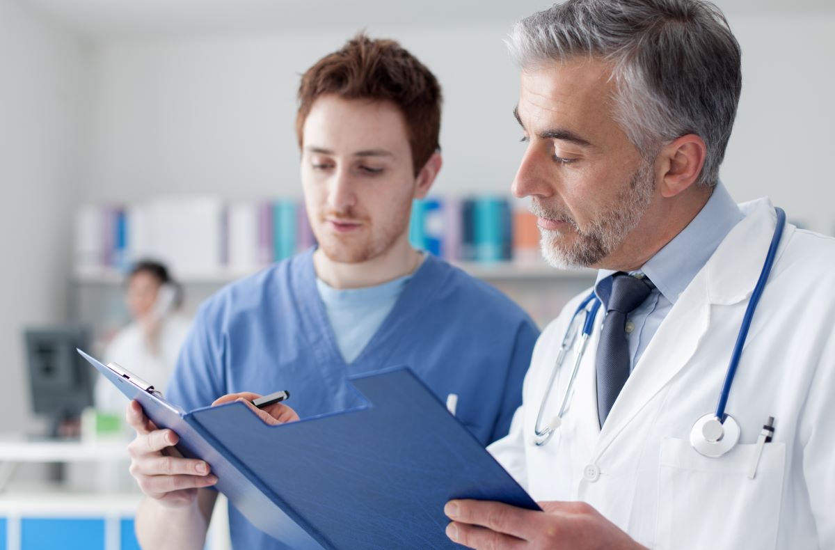 A certified medical assistant (CMA) helps a physician with patient records.