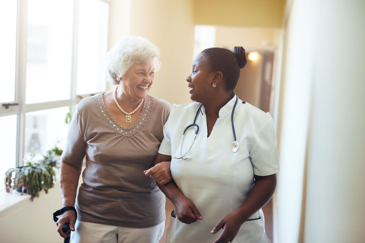 A nurse walks and shares a conversation with a nursing home resident.