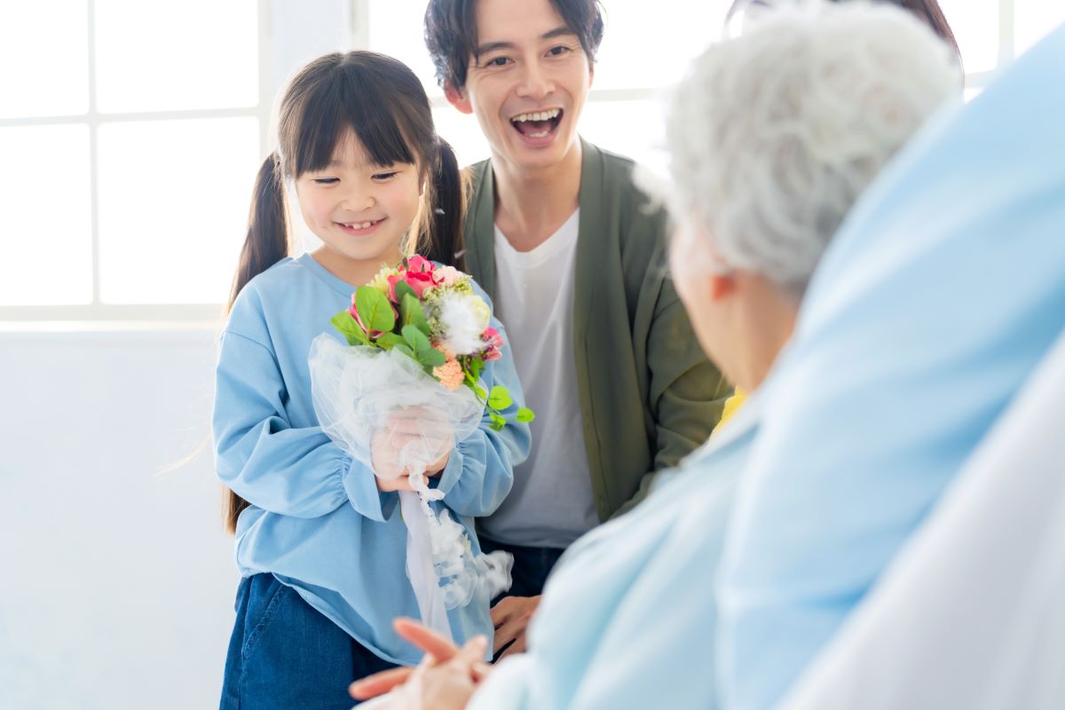 A man and his young daughter visit their loved one at a nursing home.