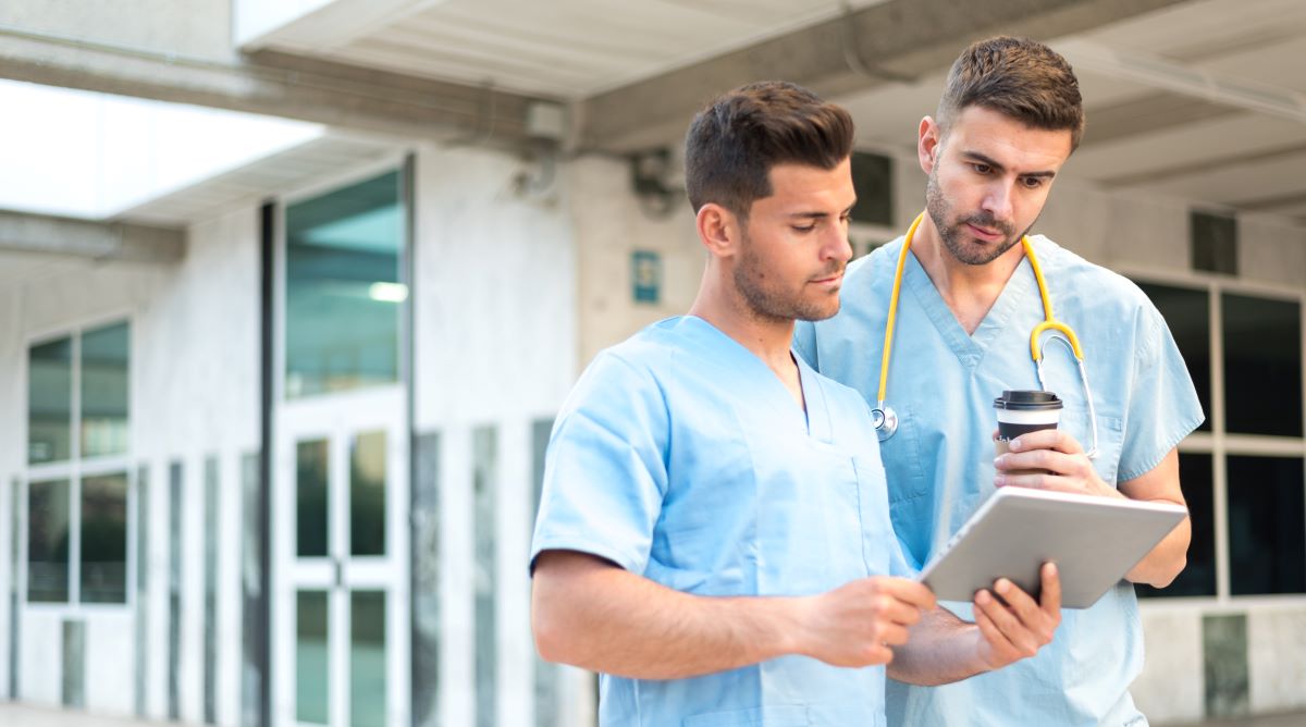 Two nurses consulting an hourly nursing shift planner.