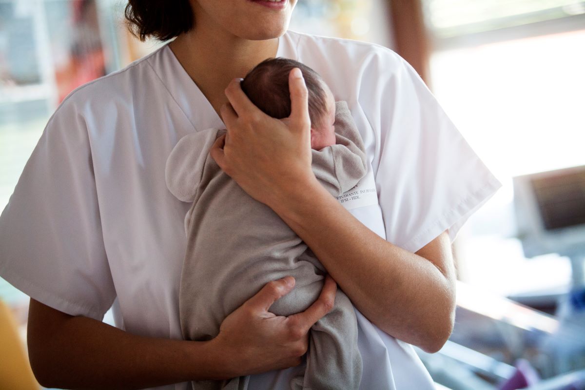 Neonatal nurse holding a newborn