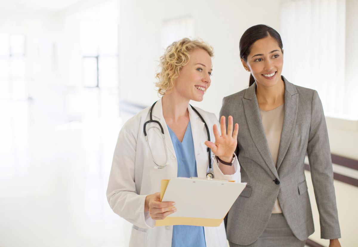 Two professional women walking through a medical office