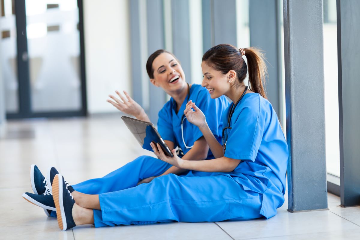 Two nurses enjoying a break together, embracing the importance of nurse wellness.