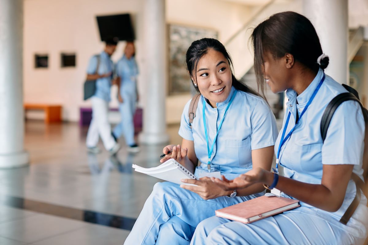 An agency nurse consults with a full time nurse at a facility to get oriented.