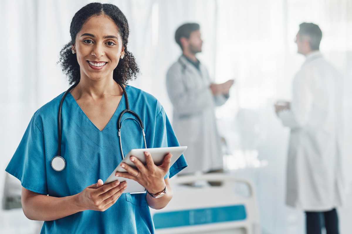 A clinical nurse leader with a clipboard, smiling