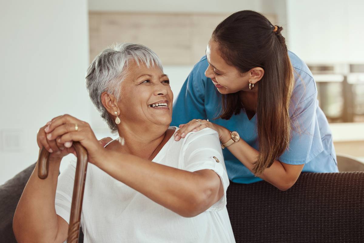 A nurse smiles at a patient during their private duty nursing shift.