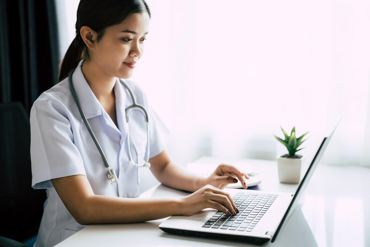 Nurse working on her LVN resume at a laptop.