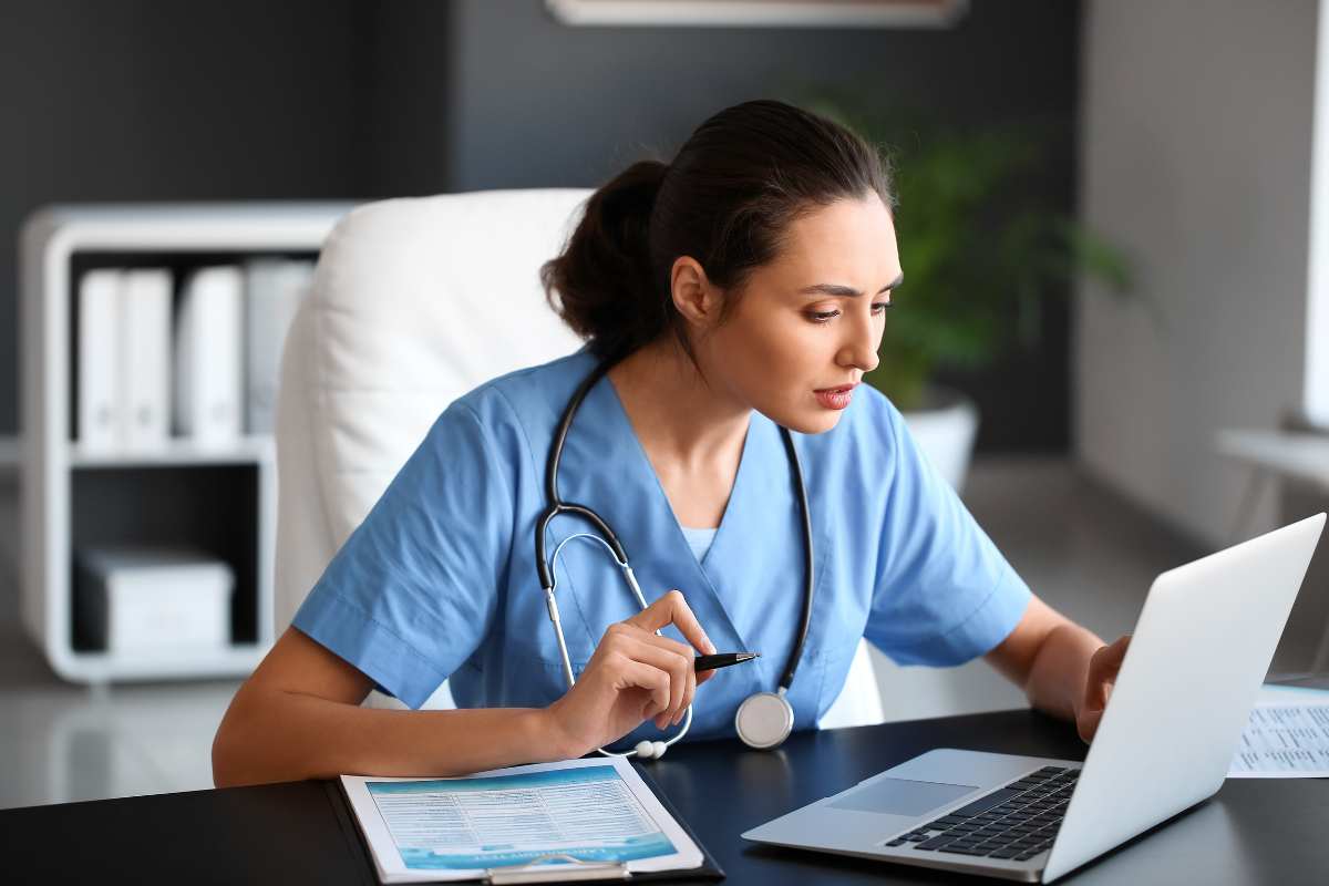 Nurse at a computer completing the Massachusetts nursing license renewal process.