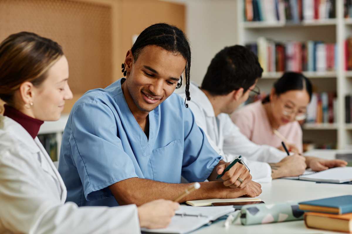 Students exchanging nursing school tips in a library.