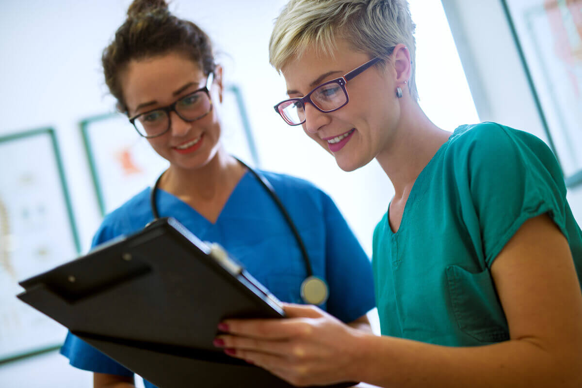 Nurses with eyeglasses checking a nursing shift change report.