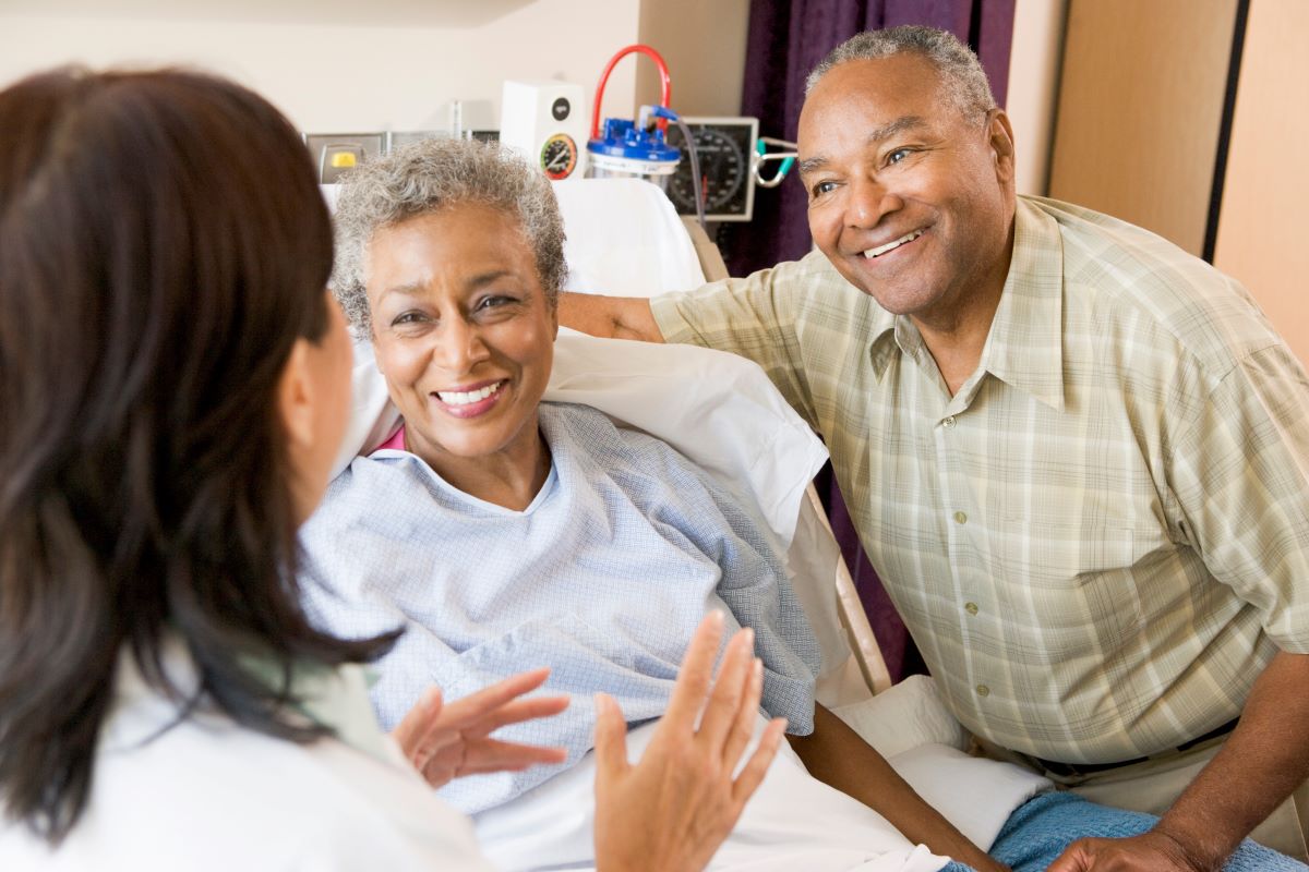 A nurse talks to a patient and her spouse.