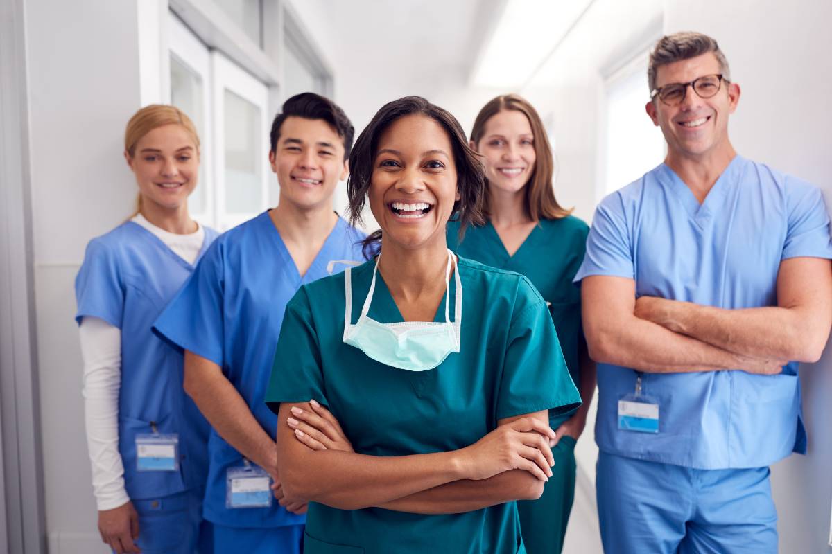 A group of nurses in blue scrubs demonstrate what makes a good nurse.
