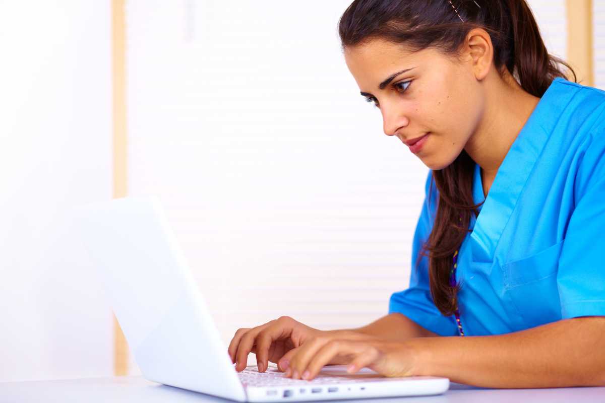 Nurse on a laptop completing the NC nursing license renewal steps.