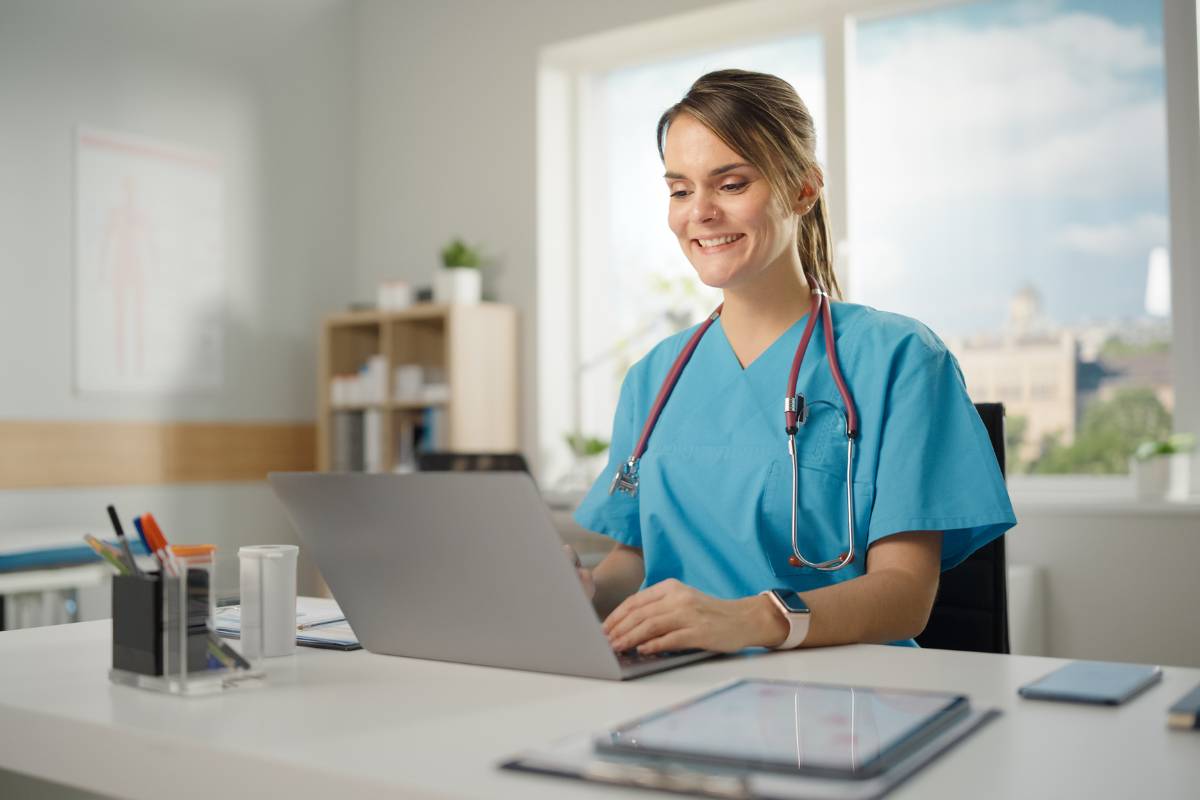 A nurse in teal scrubs searches for non-bedside nursing jobs.