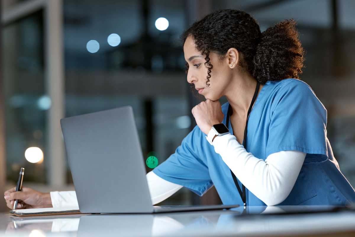 Nurse in front of laptop completing PA nursing license renewal application.