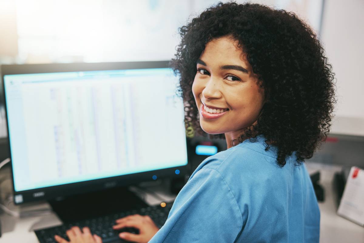 A woman in blue scrubs shows the benefits of technology in nursing.