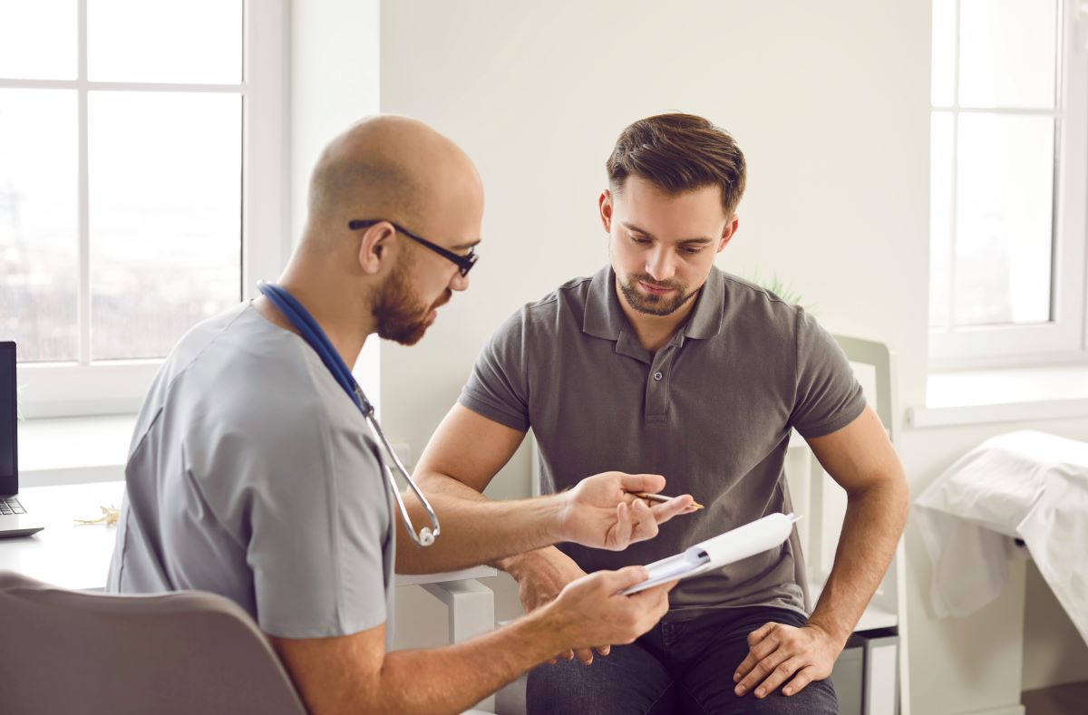 A certified medical assistant goes over some information with a patient.