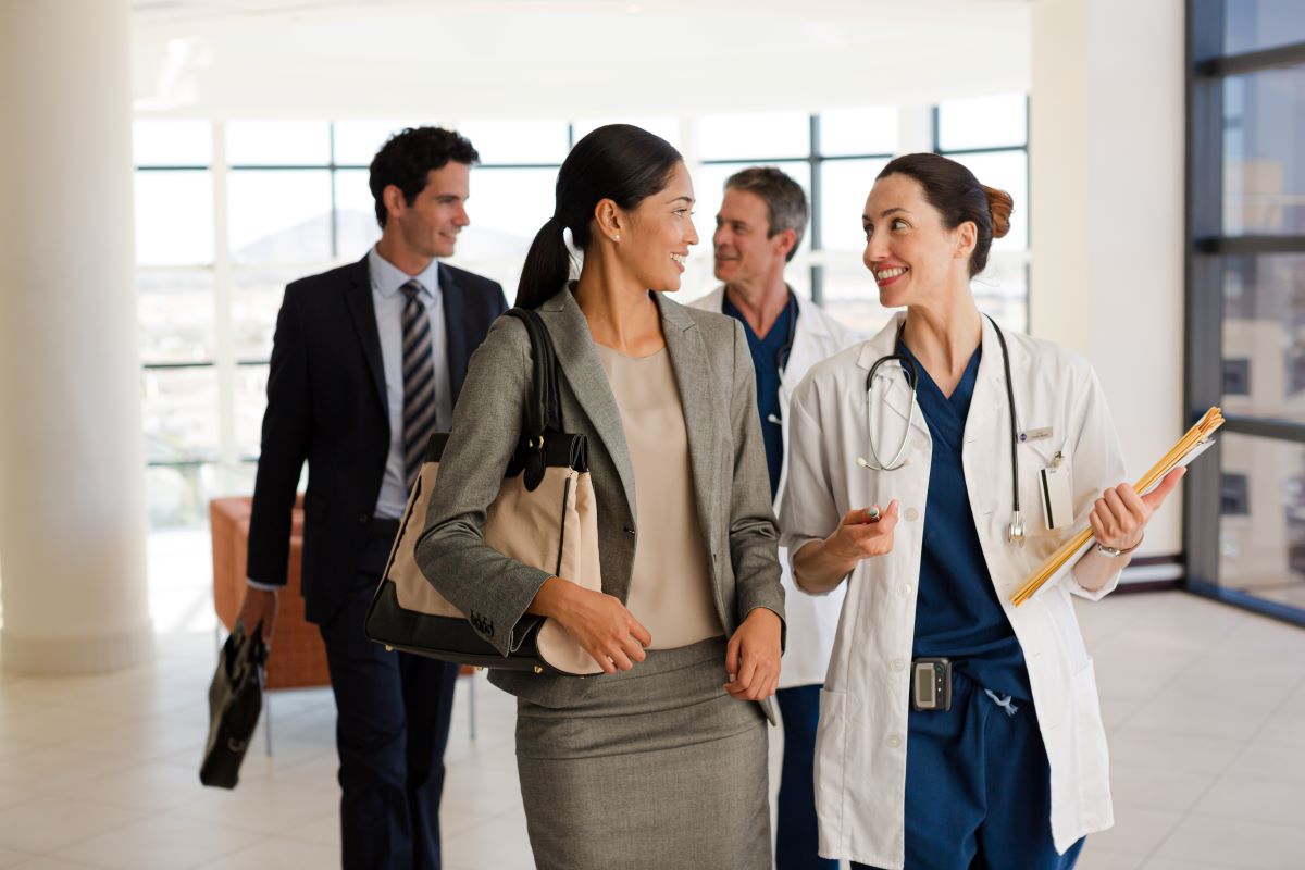 Candidates for a healthcare facility's COO position walk down the hallway.