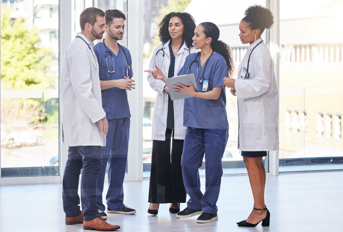 A medical scheduler meets with nurses and physicians.