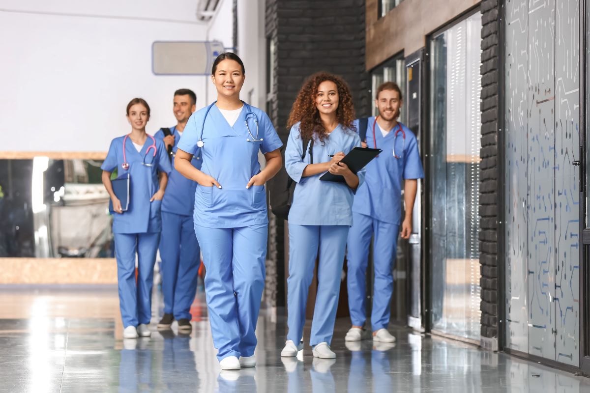 Group of nurses standing together in hallway.
