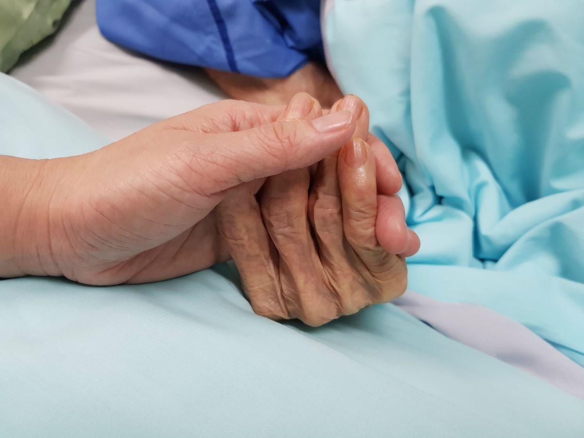 A nurse provides comfort care for a terminally ill patient.