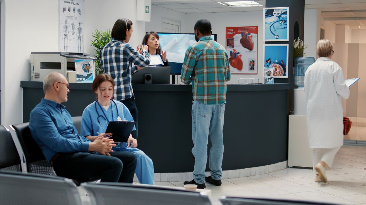 A busy doctor's office, with many patients, nurses, and administrators.