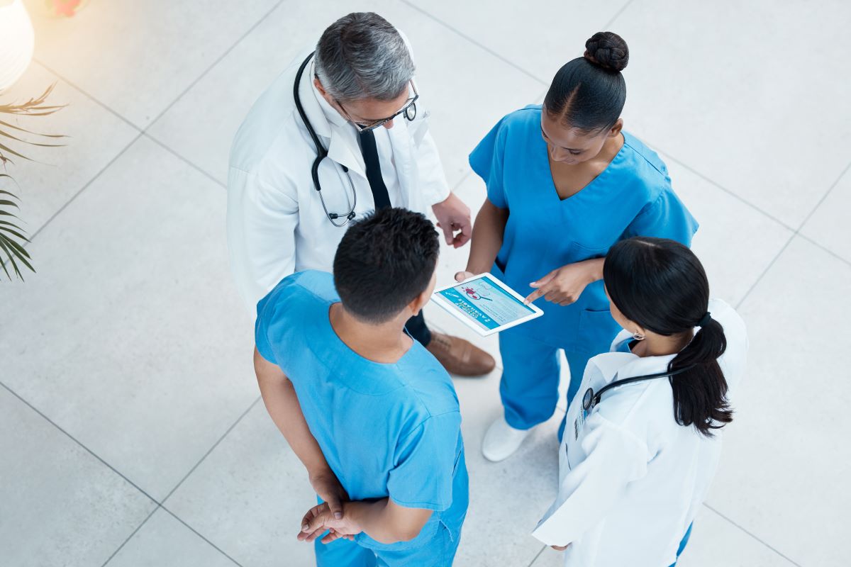 A team of physicians and nurses reviews patient data.
