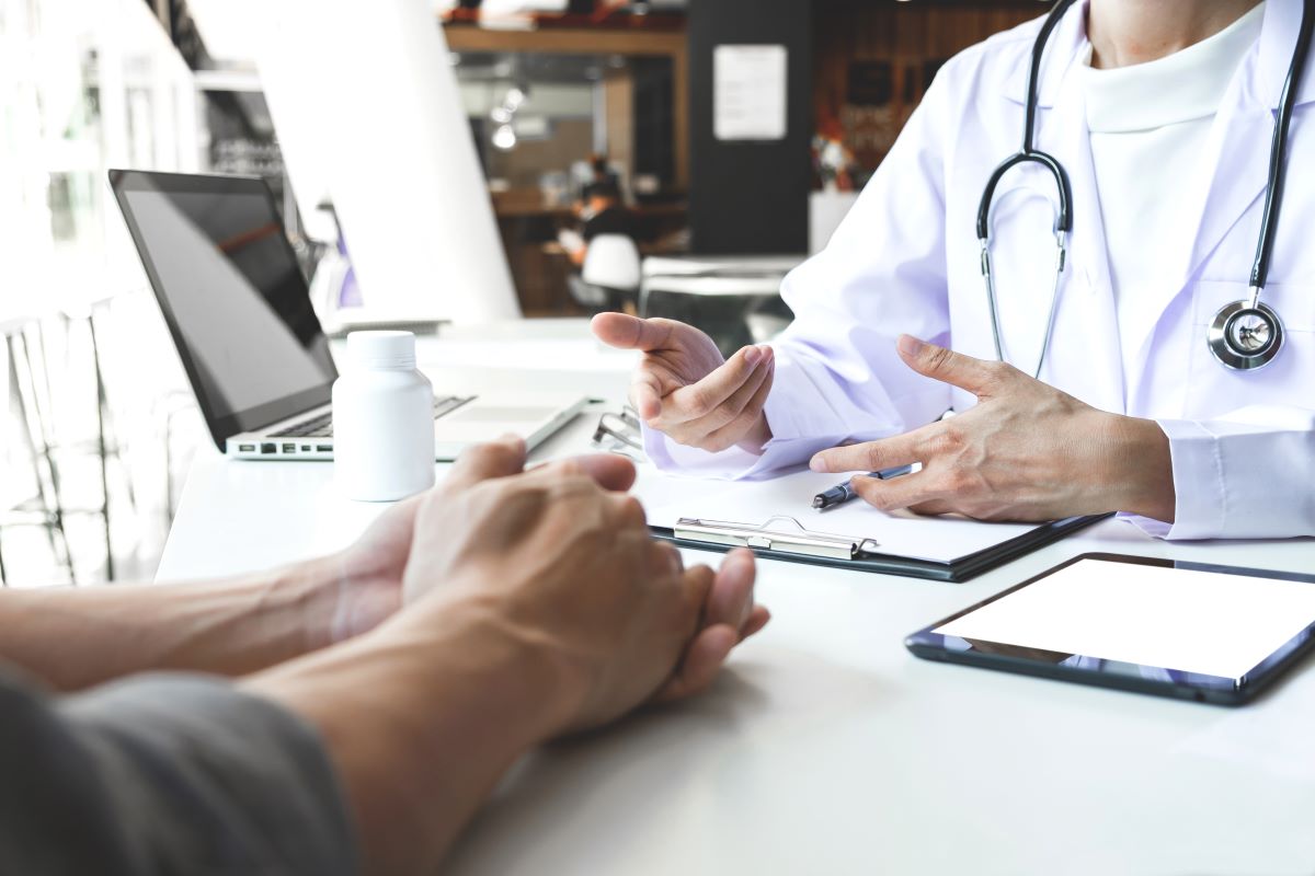 A nurse administrator talks to a patient about a physician referral.