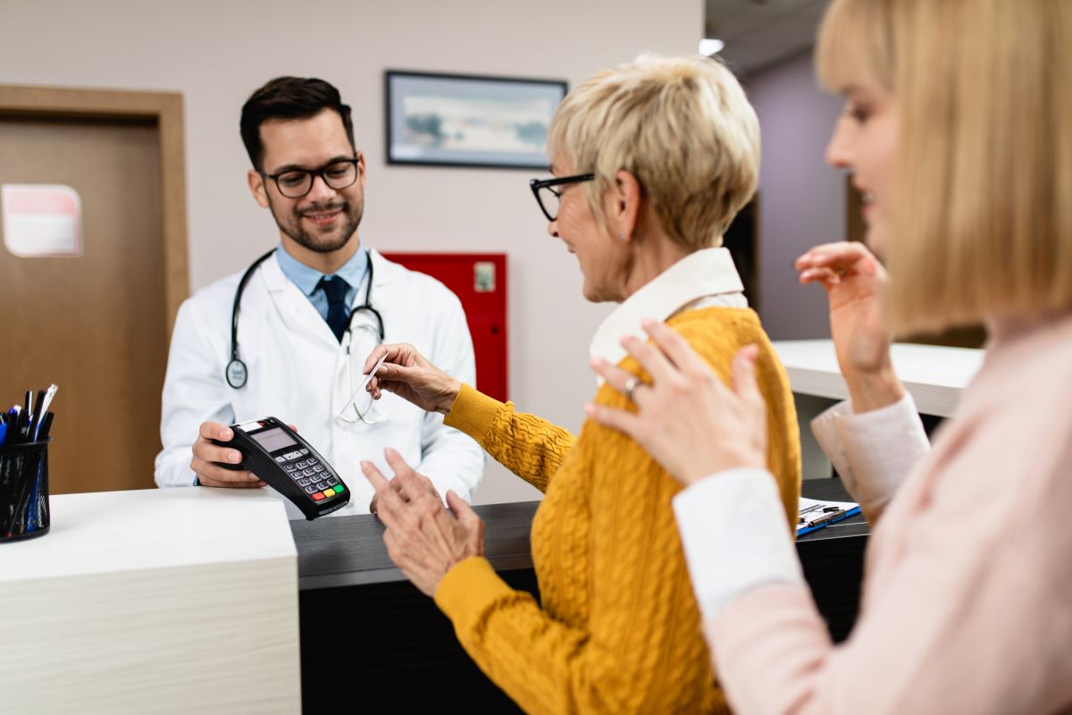 A patient pays for her medical services at the counter.