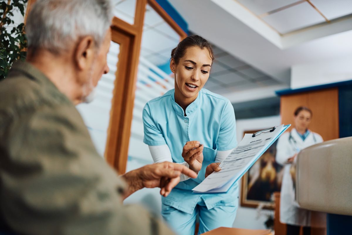 A nurse shows a medical document to her patient.