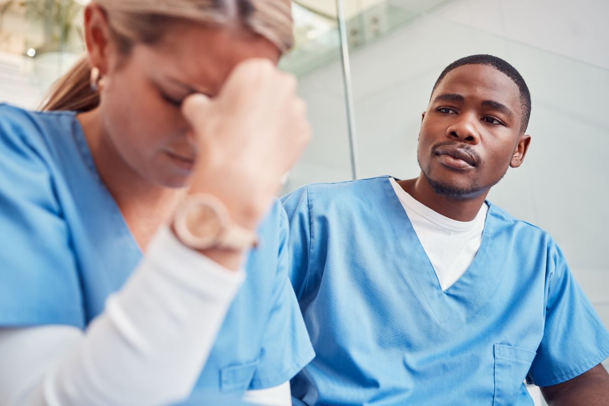 A nurse comforts a fellow nurse who is suffering from compassion fatigue.