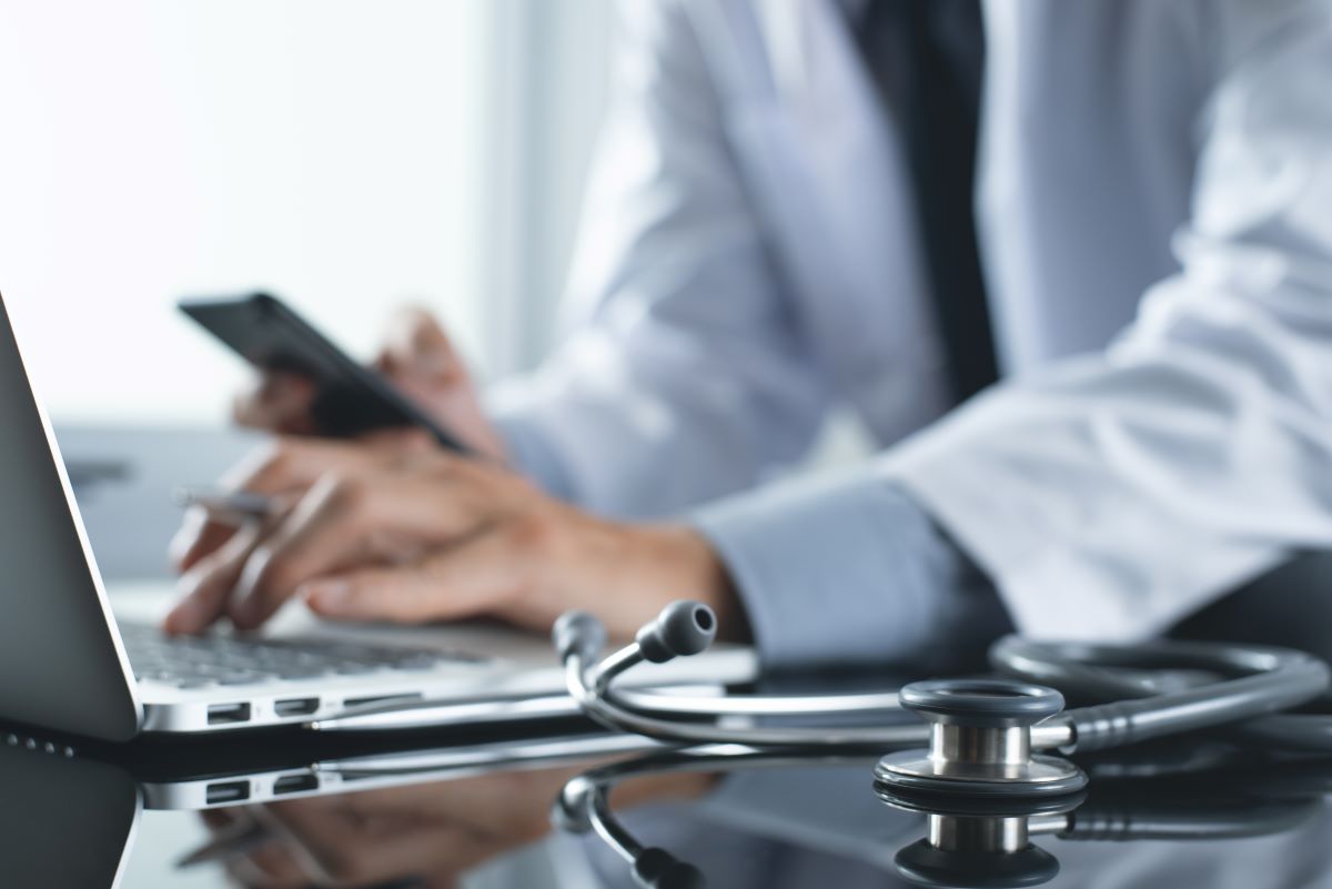 A physician checks patient data on an EHR system.