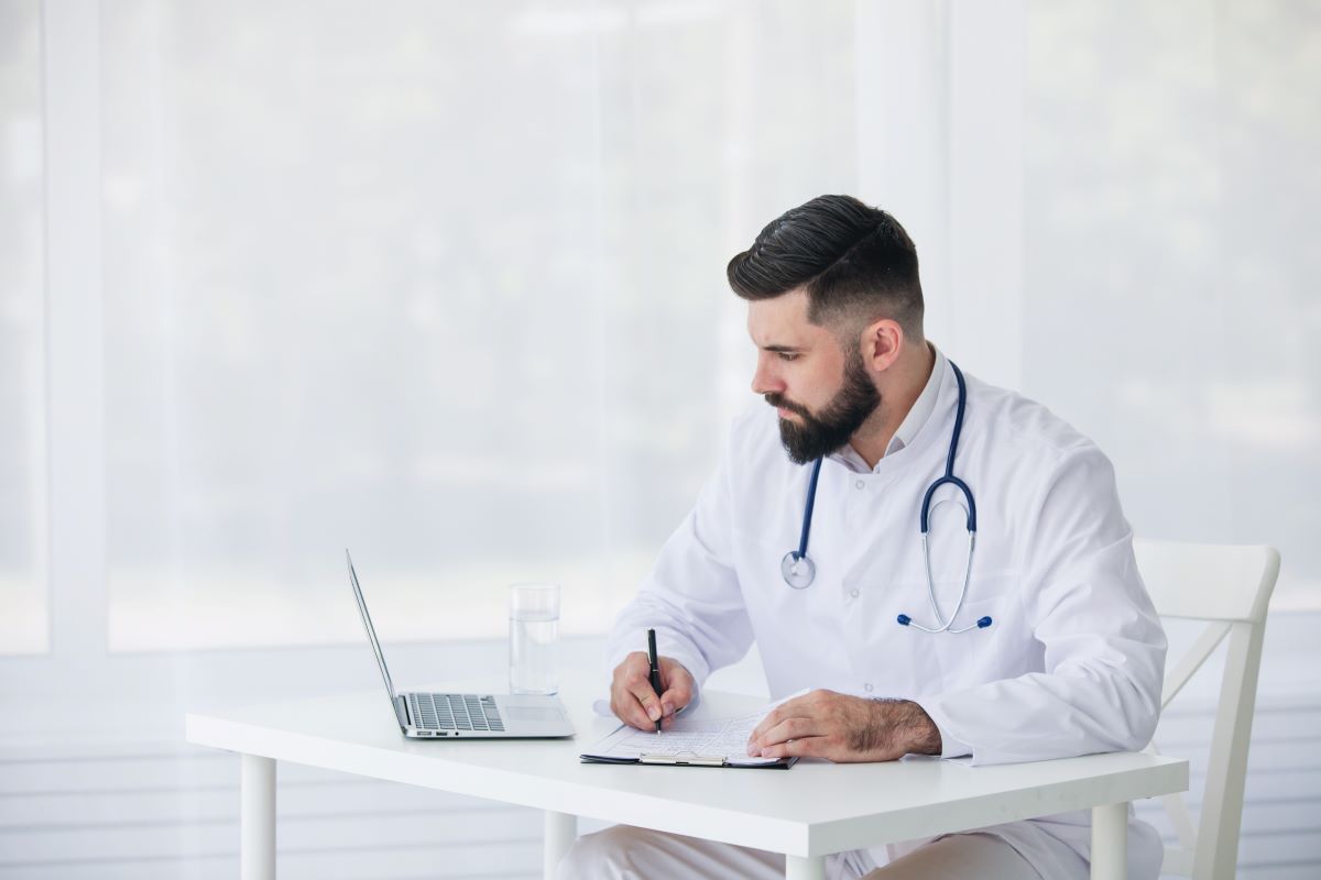 The chief clinical officer at a medical facility does research at his desk.