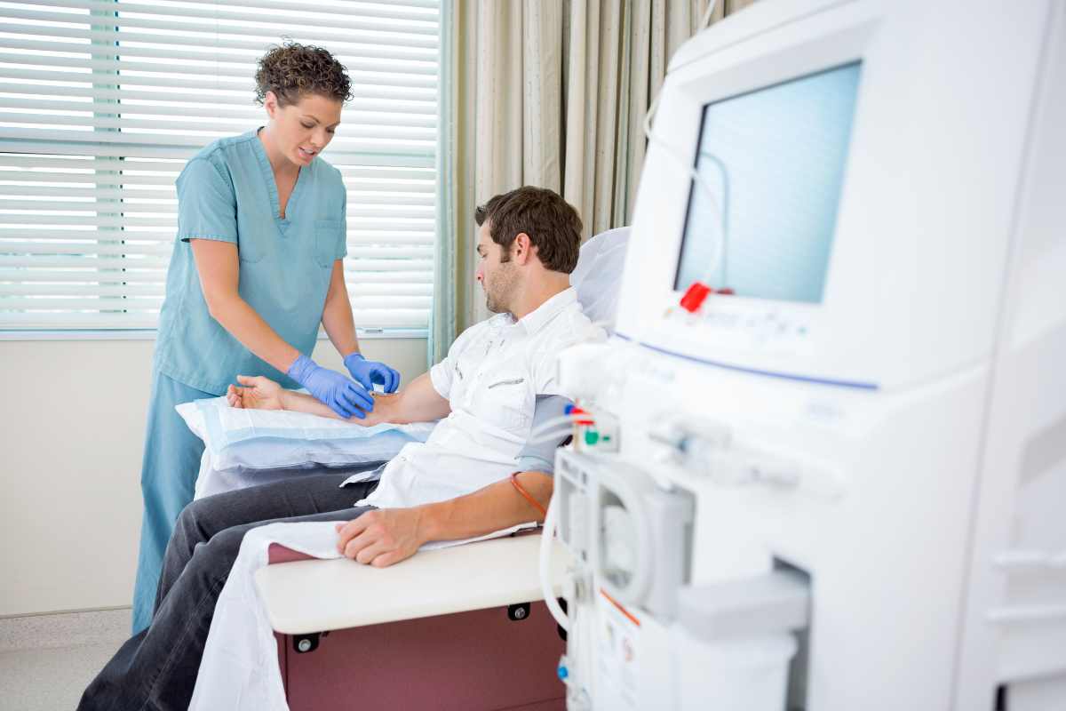 Dialysis nurse hooking up a patient to a machine