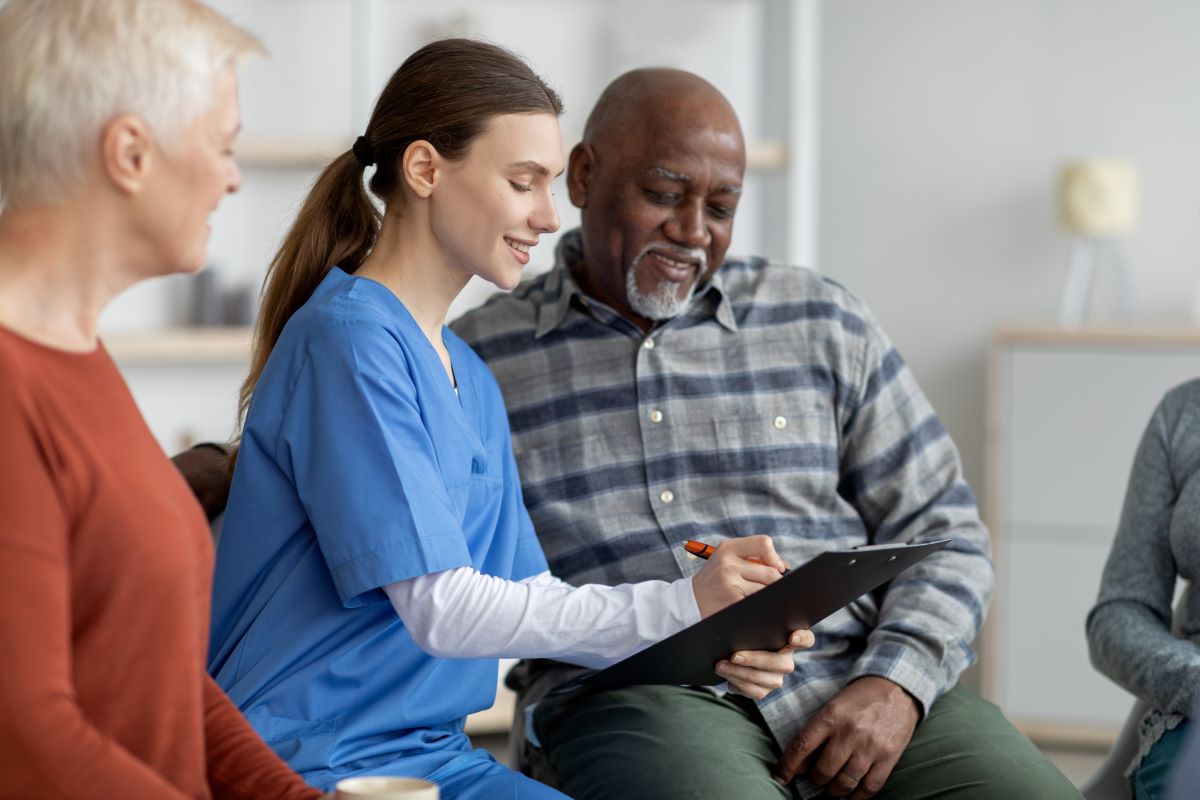 A nurse at a long-term care facility goes over records with a resident.