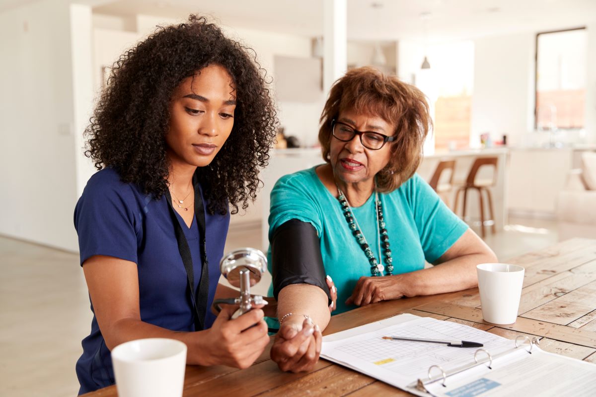 A nurse checks a nursing home resident's blood pressure.