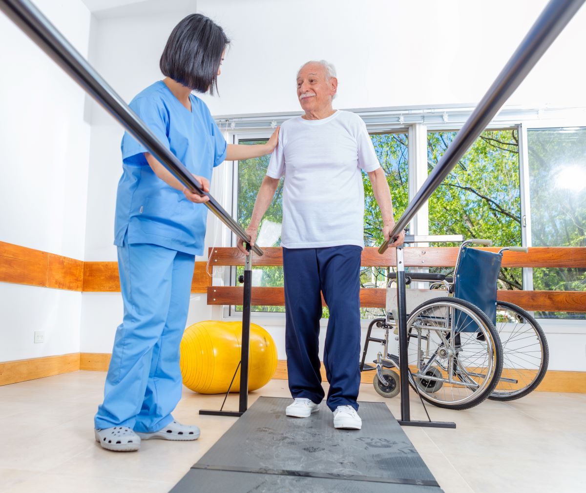 A long term care nurse helps a resident with his daily physical therapy.